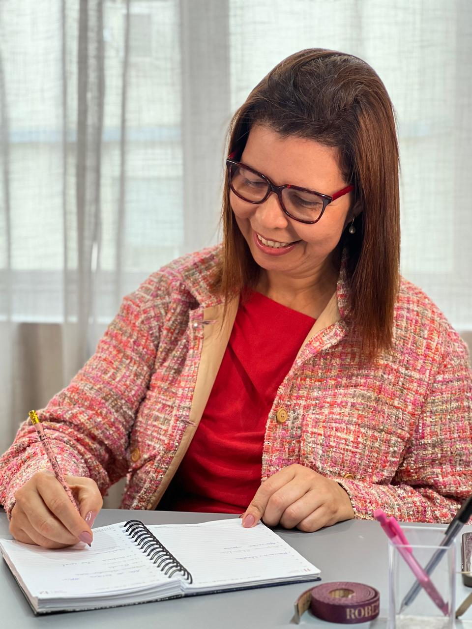 Dionete Almeida, fundadora do Ateliê Di Almeida, planejando criações em seu escritório